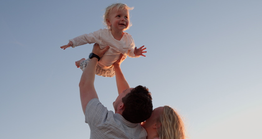 Family on beach at sunset during video session